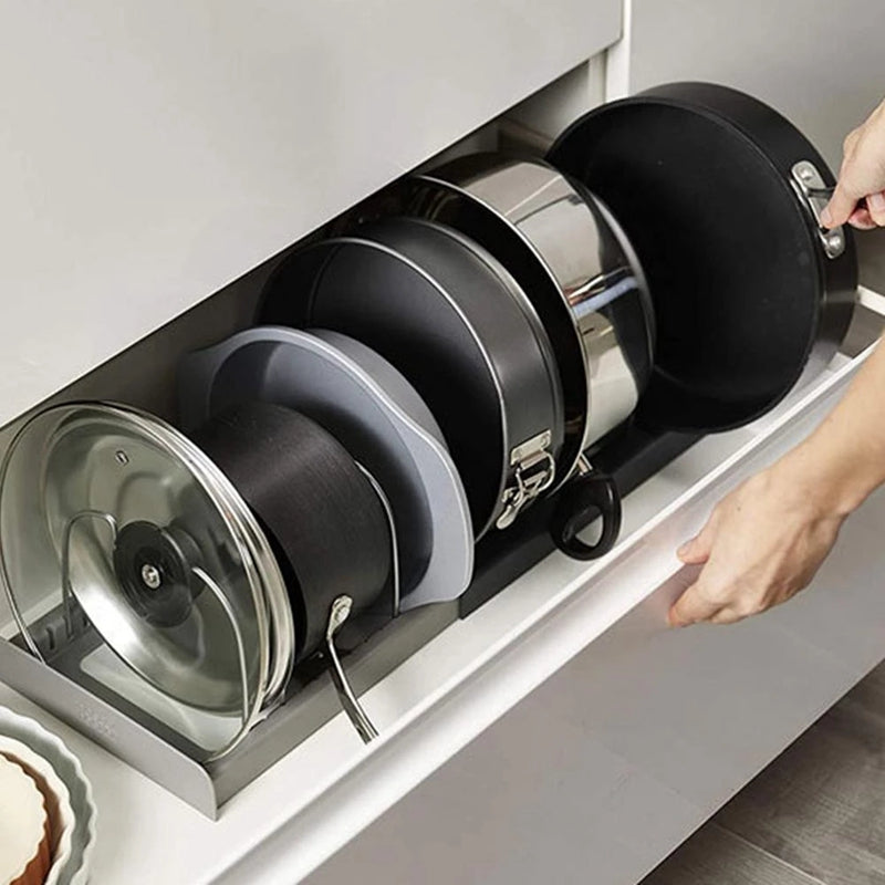 Expandable pan and lid organizer with adjustable dividers inside a kitchen drawer